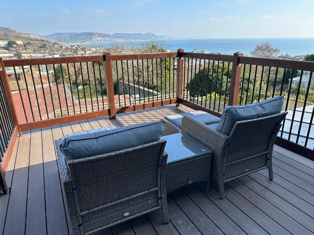 two chairs and a table on a deck with the ocean at The Nags Head - Room only accommodation in Lyme Regis