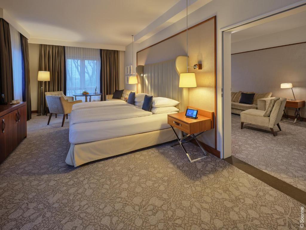 a hotel room with a large bed and a desk at Dorint Hotel Bonn in Bonn
