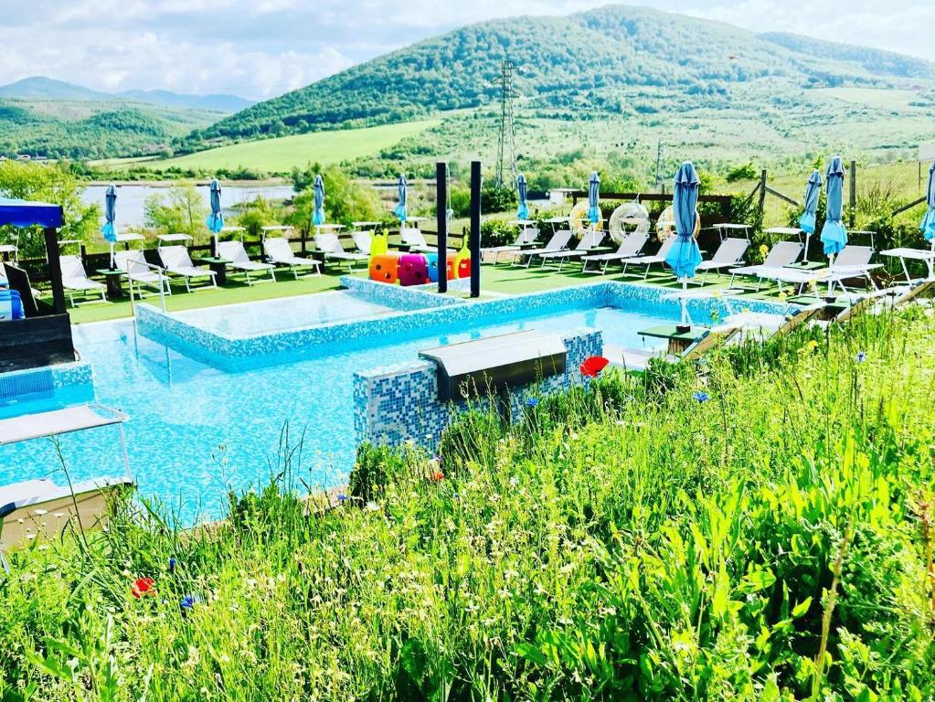 una piscina con tumbonas y un complejo en Glamping&BeerSpa Scialla Sul Lago, en Pignola