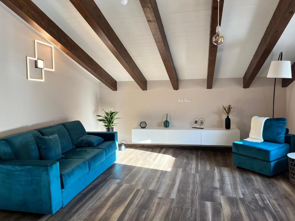 a living room with blue furniture and wooden ceilings at Bellavista Mansion in Agerola