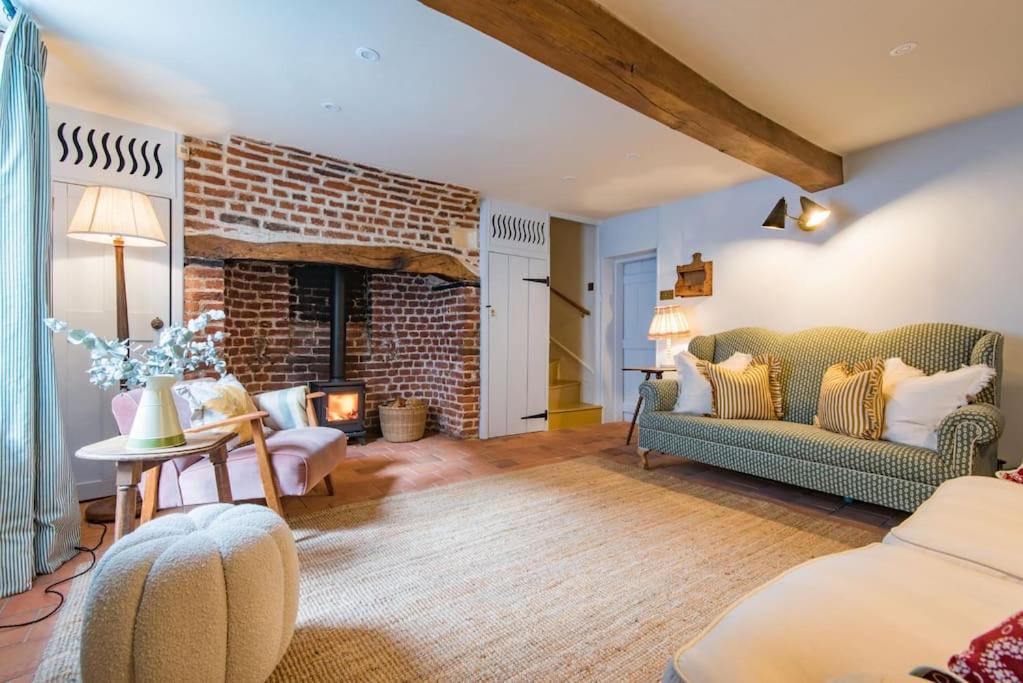 a living room with a couch and a fireplace at Rogue's Cottage - Secluded gem by the sea in Deal