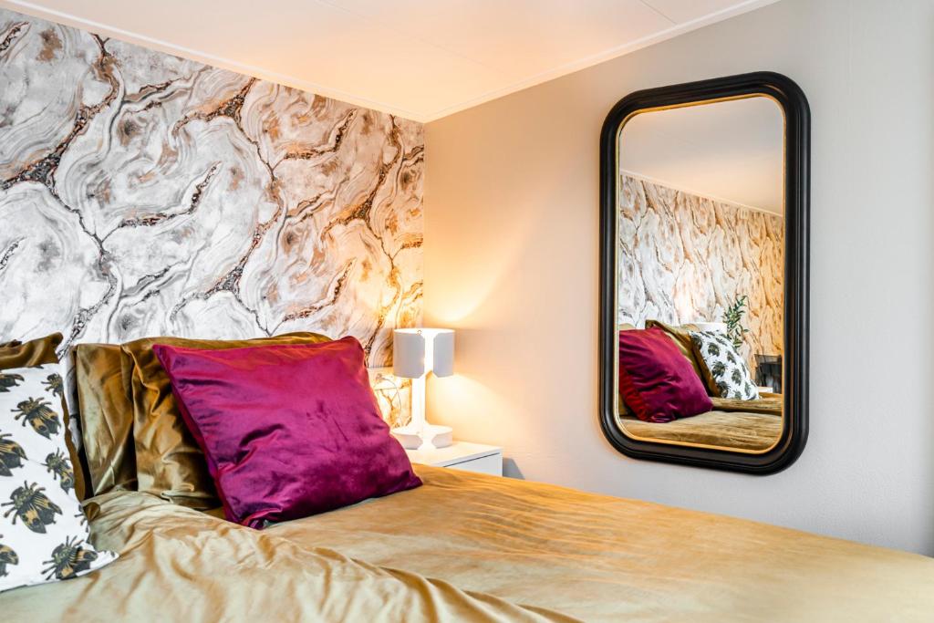 a bedroom with a bed and a mirror at Charley's Wellness Suite in Westkapelle