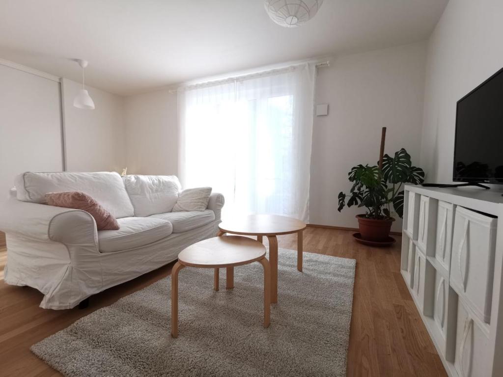 a living room with a white couch and a table at Gemütliches Privatzimmer in geräumiger Gemeinschaftswohnung in Dresden