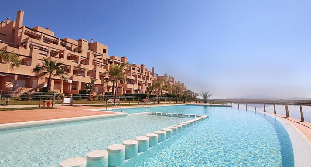 einem großen Pool vor einem Gebäude in der Unterkunft Casa Leona: Fully furnished, secure golf resort penthouse apartment with gorgeous views in Murcia in Murcia