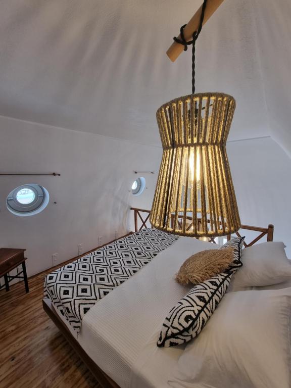 a bedroom with a bed with a chandelier at Lovely House at Oia Village Center in Oia