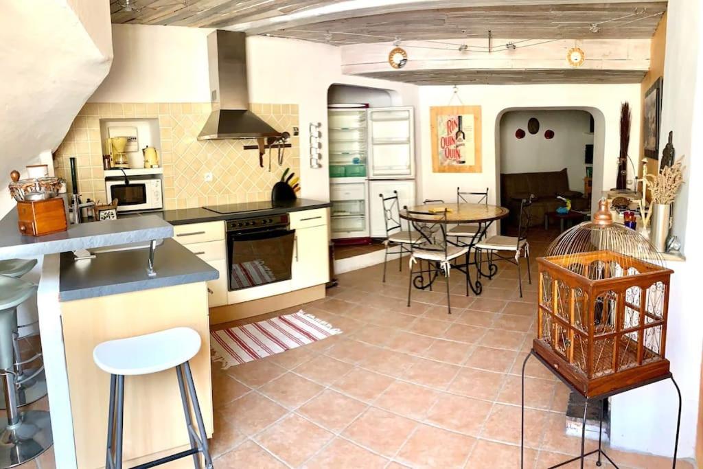 a large kitchen with a table and chairs in it at Coquette maison de village pour 4 pers in Quinson