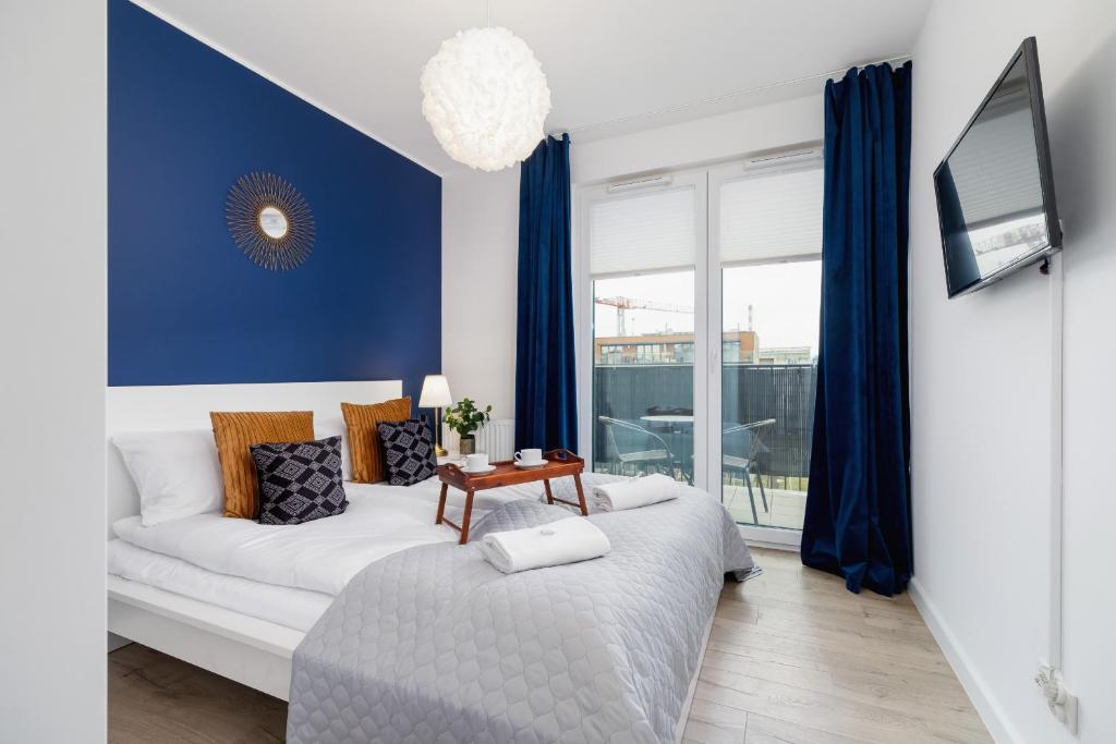 sala de estar con sofá blanco y paredes azules en Fredry 6 Apartment Premium Łagiewniki by Renters Prestige, en Cracovia
