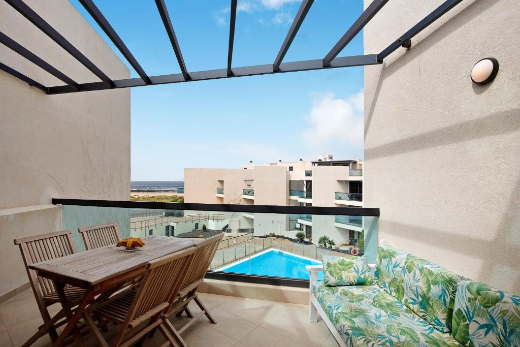 a balcony with a table and chairs and a pool at Casamar2197 in Cotillo