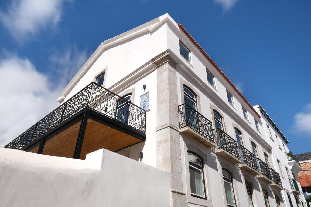 a white building with a balcony on it at Villa Sofia Cascais in Cascais