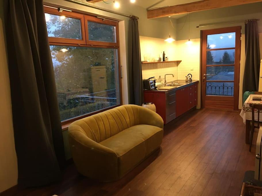 uma sala de estar com um sofá e uma cozinha em ziggy's room with a view em Heyd