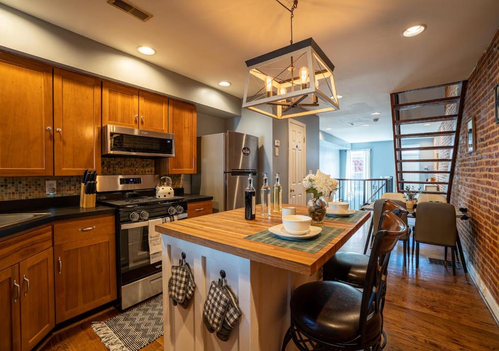 a kitchen with a kitchen island with a counter top at Cozy Townhouse Downtown w/ Game Room & Rooftop in Baltimore
