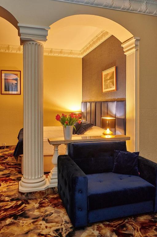 a living room with a couch and a bed at Hotel Royal in Gliwice