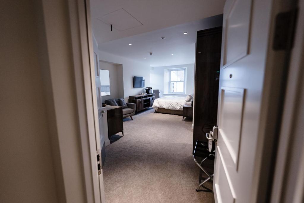 a hallway to a bedroom with a bed and a living room at Shore Hotel Laxey in Laxey