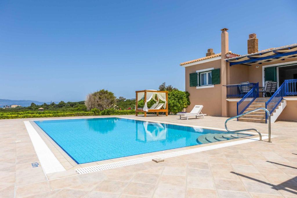 a swimming pool in front of a house at Villa Tramonto Minies in Minia
