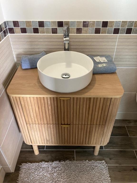 a bathroom with a white sink on a wooden counter at La marine D&#39;opale in Ambleteuse