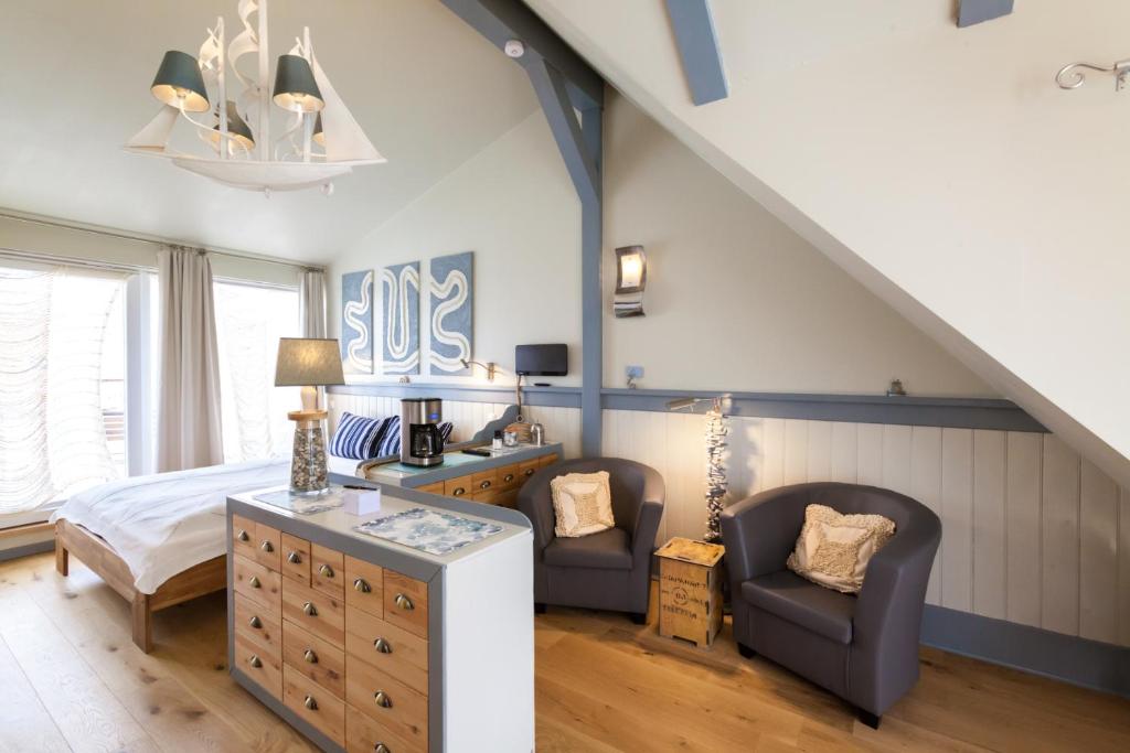 ein Schlafzimmer mit einem Bett und zwei Stühlen in der Unterkunft FeWo Engler Gartenstraße Doppelzimmer in Lüneburg