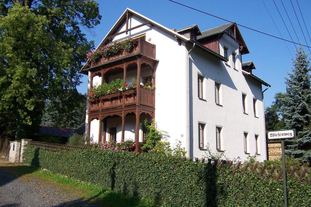 Casa blanca con balcón con flores. en Privathaus Wehle, en Kurort Gohrisch