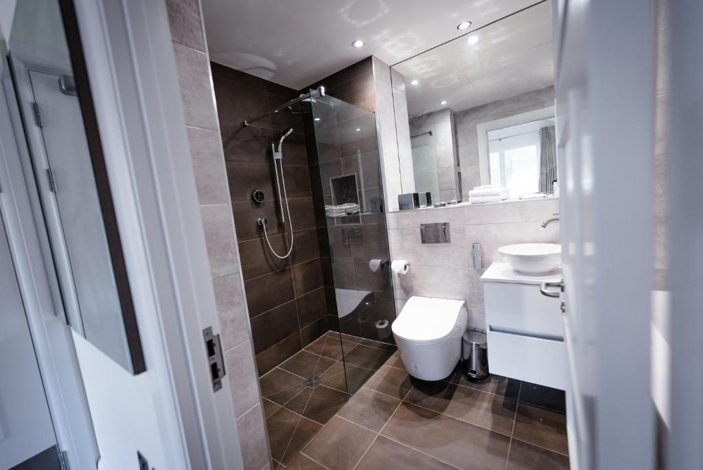 a bathroom with a shower and a toilet and a sink at Shore Hotel Laxey in Laxey