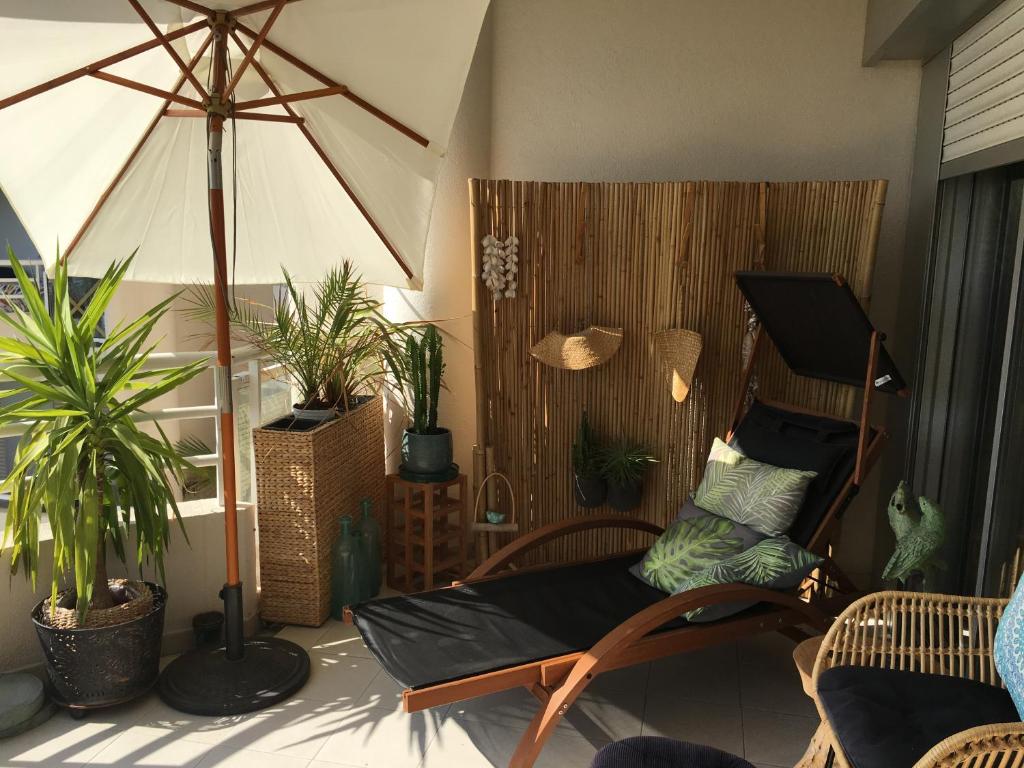 a living room with a chair and potted plants at Appartement tout confort vue mer in Antibes
