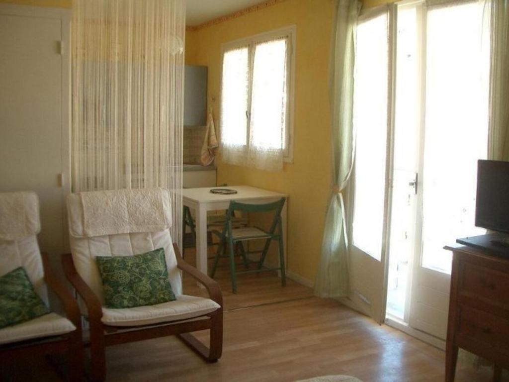 un salon avec une chaise et une table dans l'établissement Studio confortable avec balcon - Amélie-les-Bains, près des thermes et parking - FR-1-703-35, à Amélie-les-Bains-Palalda