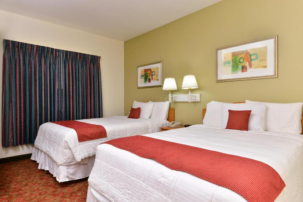 una camera d'albergo con due letti e una finestra di Americas Best Value Inn & Suites-Winnie a Winnie