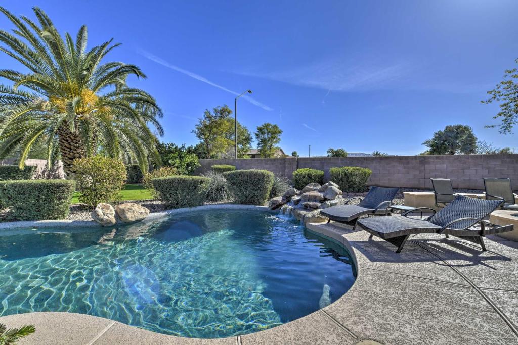 una piscina con sillas y una palmera en un patio en Southeast Gilbert Home with Private Pool and Hot Tub!, en Gilbert