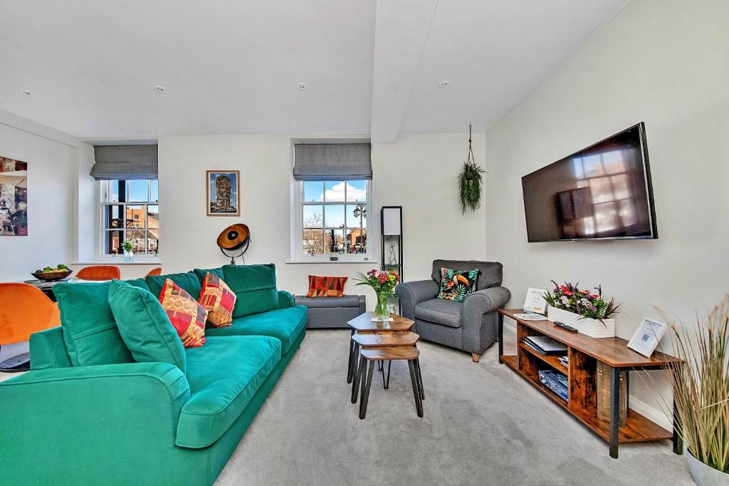 a living room with a green couch and a tv at Finest Retreats - Market View in Ripon