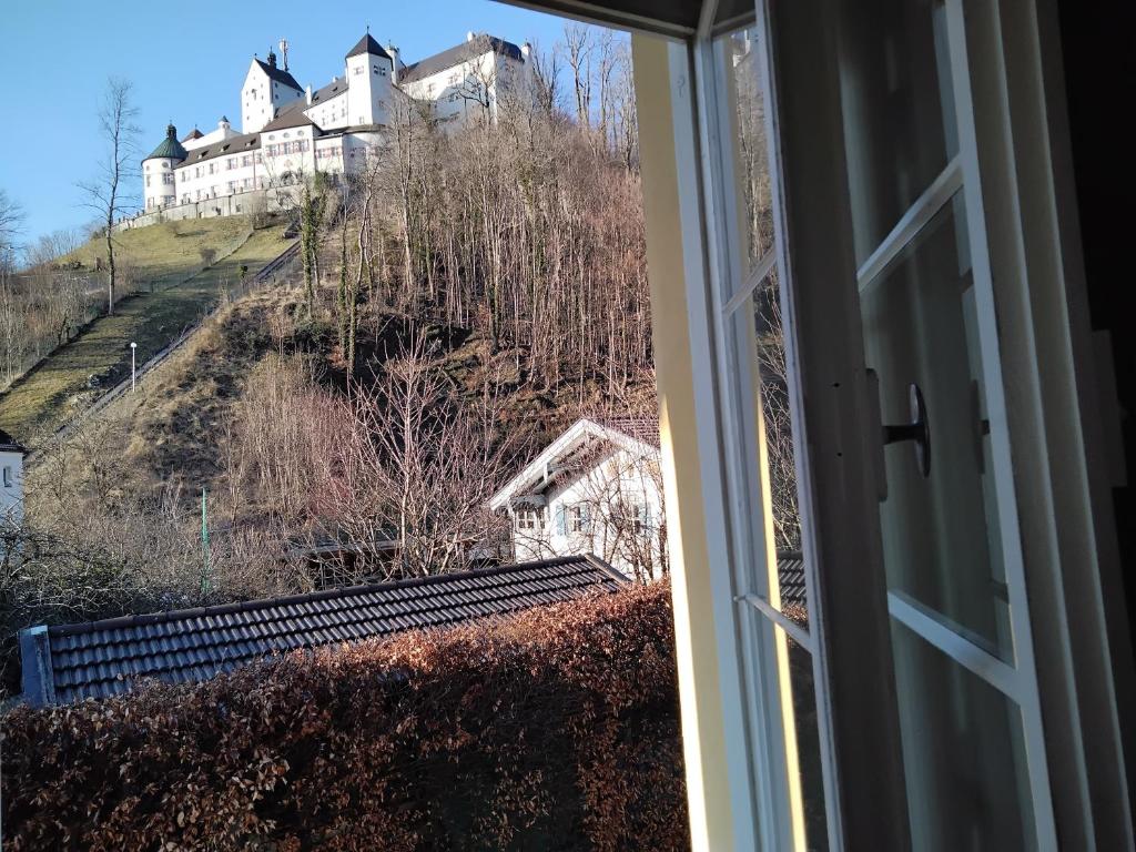 een raam met uitzicht op een huis op een heuvel bij ciao-aschau Haus zur Burg Ap112 Burgblick in Aschau