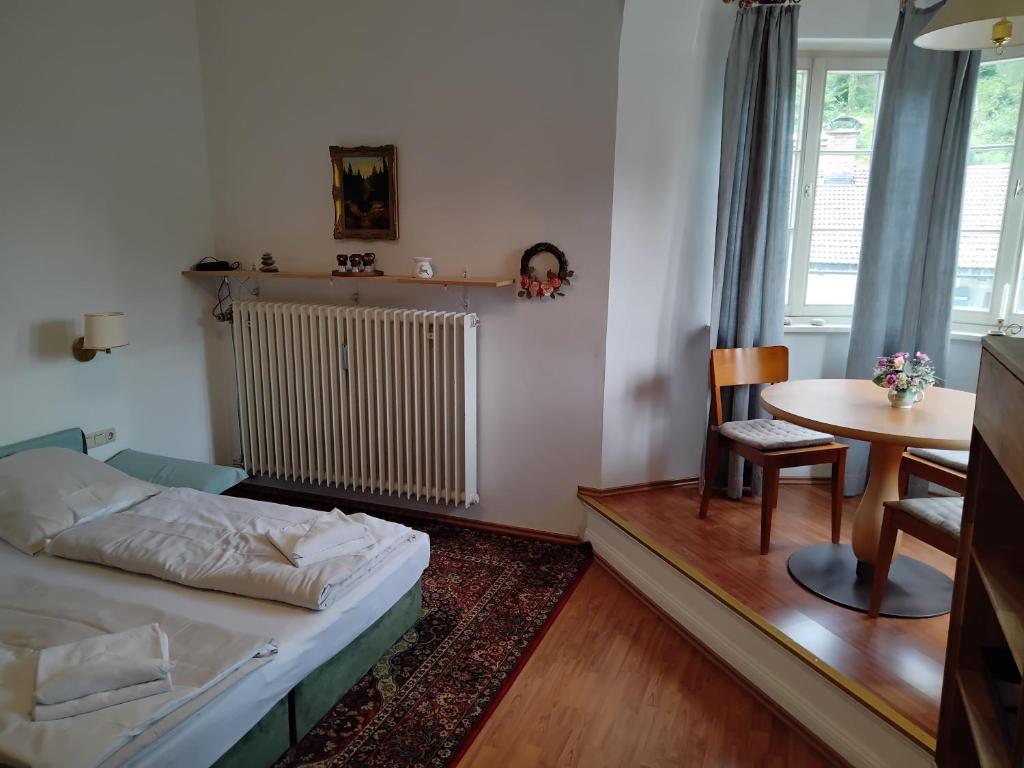 ein kleines Schlafzimmer mit einem Bett und einem Tisch in der Unterkunft ciao-aschau Haus zur Burg Ap108 Weber in Aschau