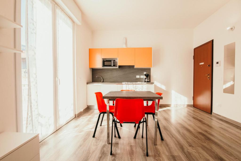 une cuisine et une salle à manger avec une table et des chaises rouges dans l'établissement AL 13 Rosso - Lakeside Leisure & Business, à Stresa