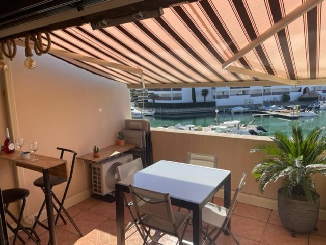 d'un balcon avec une table et une vue sur le port de plaisance. dans l'établissement HAMEAU DES CAPELLANS Duplex avec superbe vue marina piscine wifi gratuit parking gratuit, à Saint-Cyprien