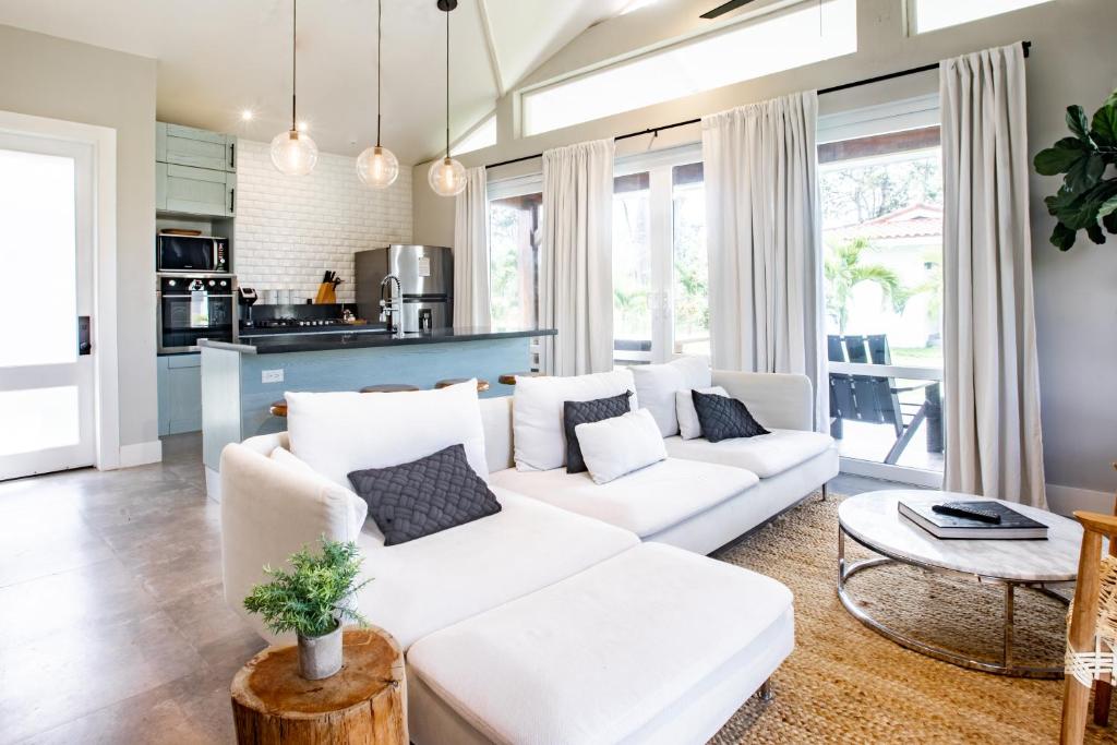 ein Wohnzimmer mit einem weißen Sofa und einem Tisch in der Unterkunft Villa #32 - Blue Venao, Playa Venao in Playa Venao