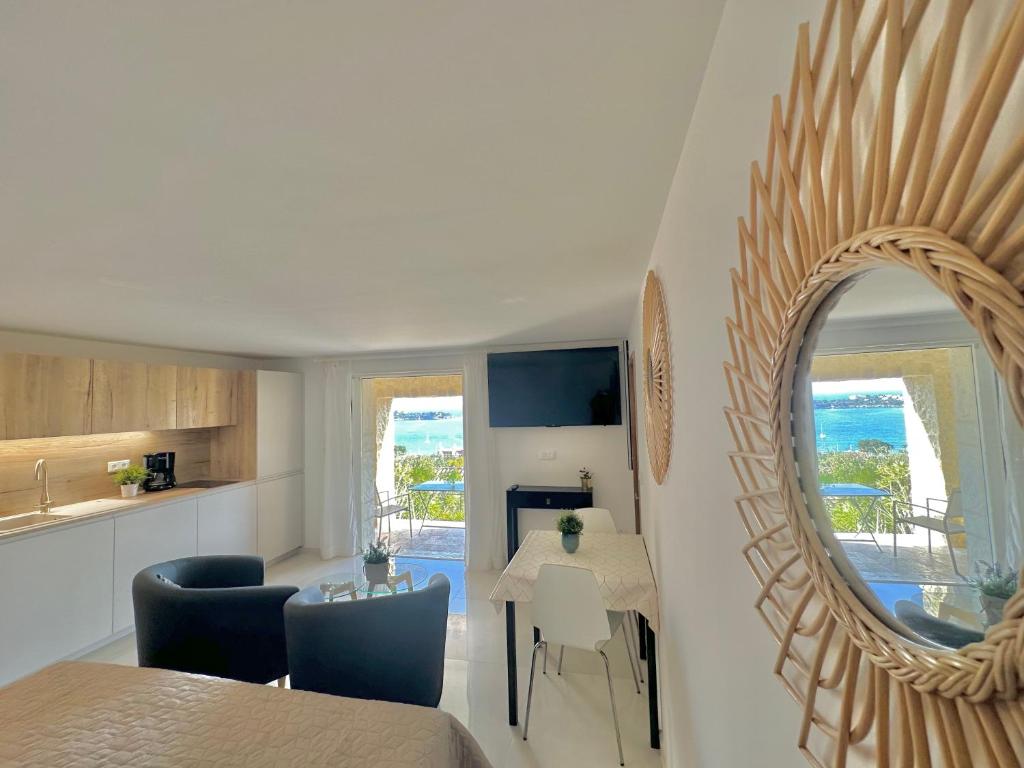 eine Küche und ein Wohnzimmer mit einem Spiegel und einem Tisch in der Unterkunft Villa Grand Baie in Agay - Saint Raphael