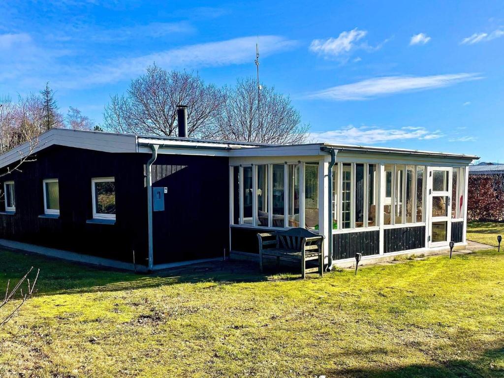 een zwart huis met een afgeschermde veranda bij Holiday home Ørsted XXIII in Ørsted