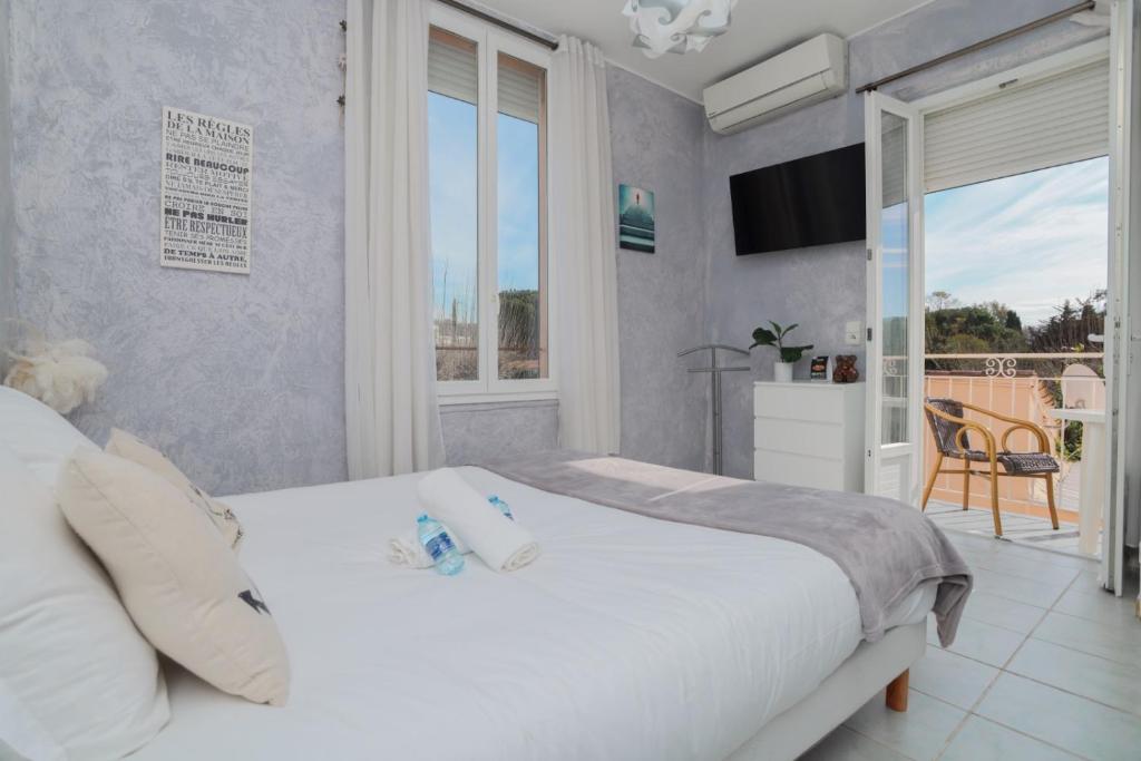 a bedroom with a large white bed and a balcony at Hostellerie LE PANEL in Mandelieu-La Napoule