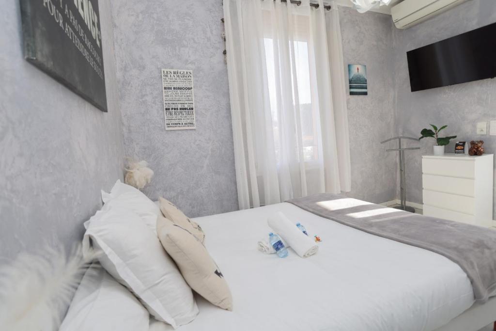 a bedroom with a bed with white sheets and pillows at Hostellerie LE PANEL in Mandelieu-La Napoule