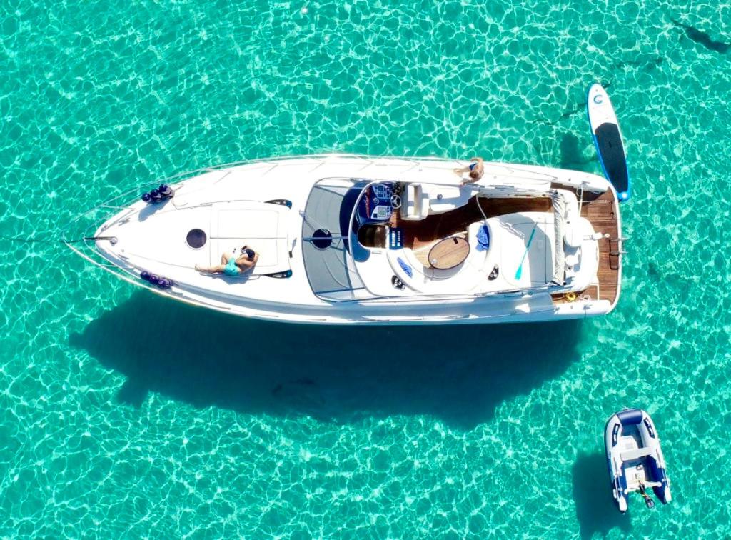 Una barca bianca in acqua con due persone sopra. di Instagrammable Yacht Hotel Malta a Il- Gżira