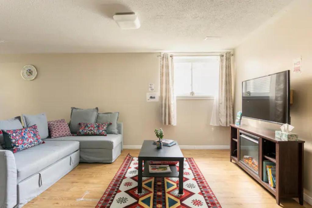 a living room with a couch and a tv at Self check-in spacious apartment with full Kitchen in Ottawa
