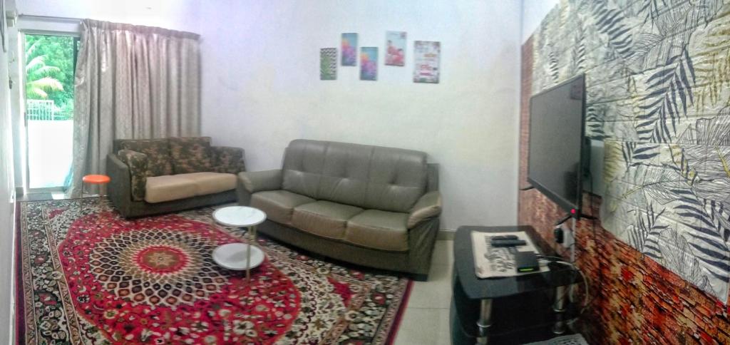 - un salon avec un canapé et une télévision dans l'établissement Homestay Lestari KLIA, à Sepang