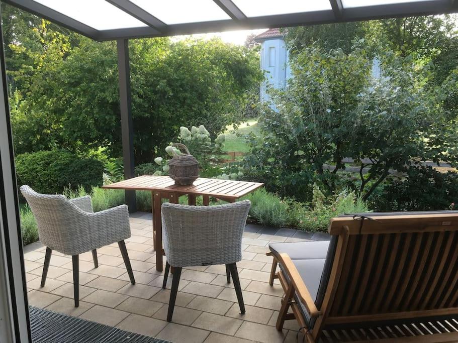 a patio with a table and chairs on a patio at Ferienwohnung am Bach 