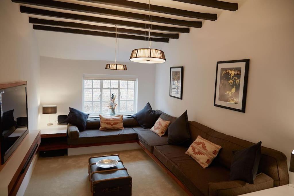 een woonkamer met een bank en een tafel bij Duck Cottage in the centre of Henley in Henley on Thames