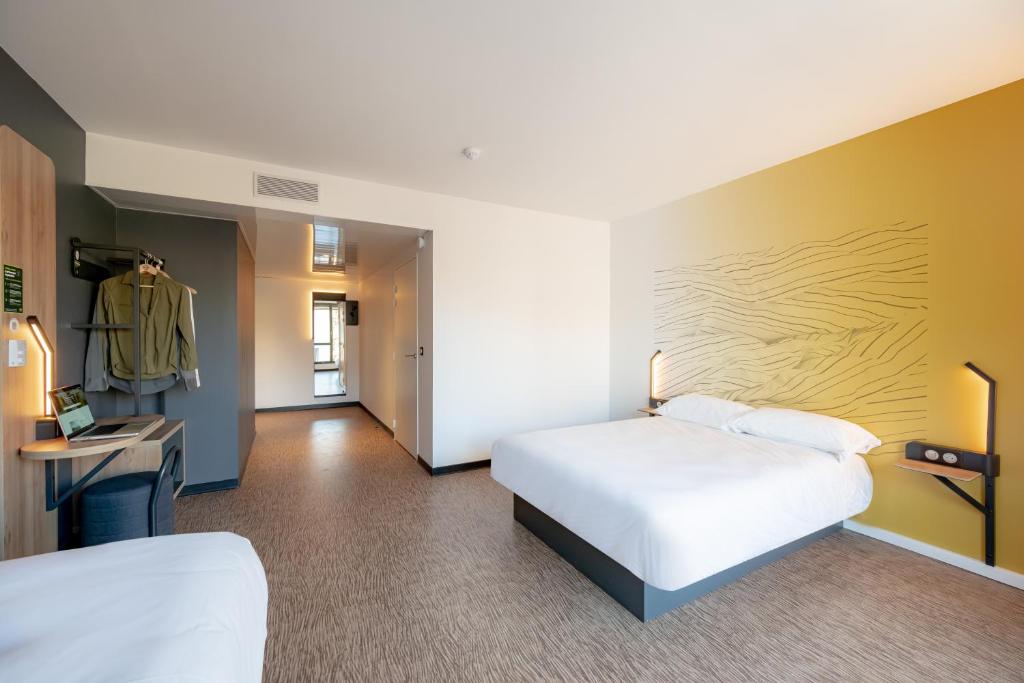 una camera d'albergo con 2 letti e una scrivania di B&B HOTEL Toulon Centre Gare a Tolone