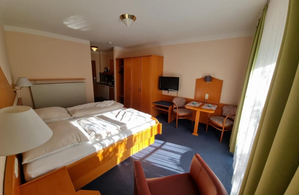 ein Hotelzimmer mit einem Bett, einem Tisch und Stühlen in der Unterkunft ciao-aschau Haus zur Burg Apn21 Krämer in Aschau