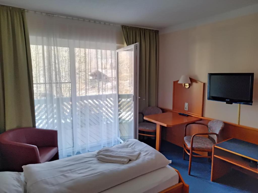 a hotel room with a bed and a desk and a television at ciao-aschau Haus zur Burg Apn220 Mina in Aschau