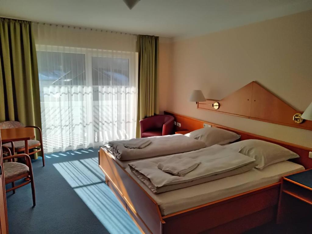 um quarto de hotel com duas camas e uma janela em ciao-aschau Haus zur Burg Apn233 Julia em Aschau