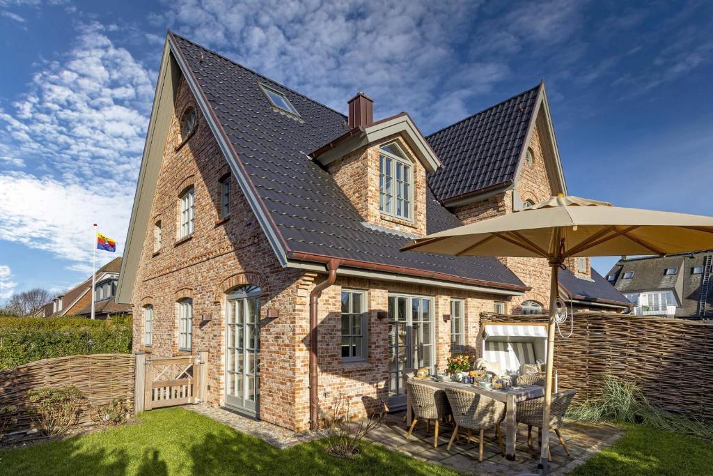 a house with a table and an umbrella at Haus Sylter Momente in Westerland