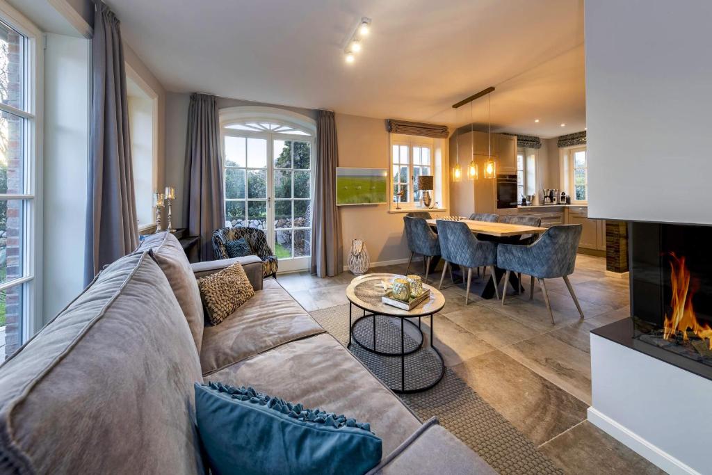 Haus Sylter Momente في فيسترلاند: غرفة معيشة مع أريكة ومدفأة