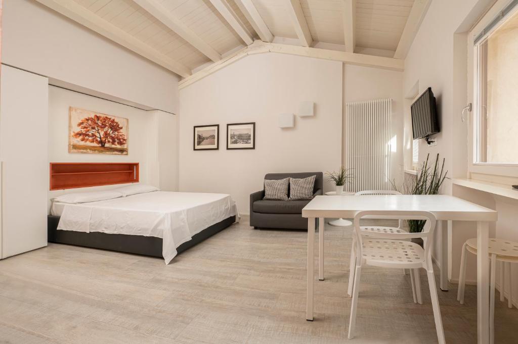 ein Schlafzimmer mit einem Bett, einem Tisch und einem Sofa in der Unterkunft Vicolo Zini Apartments in Verona