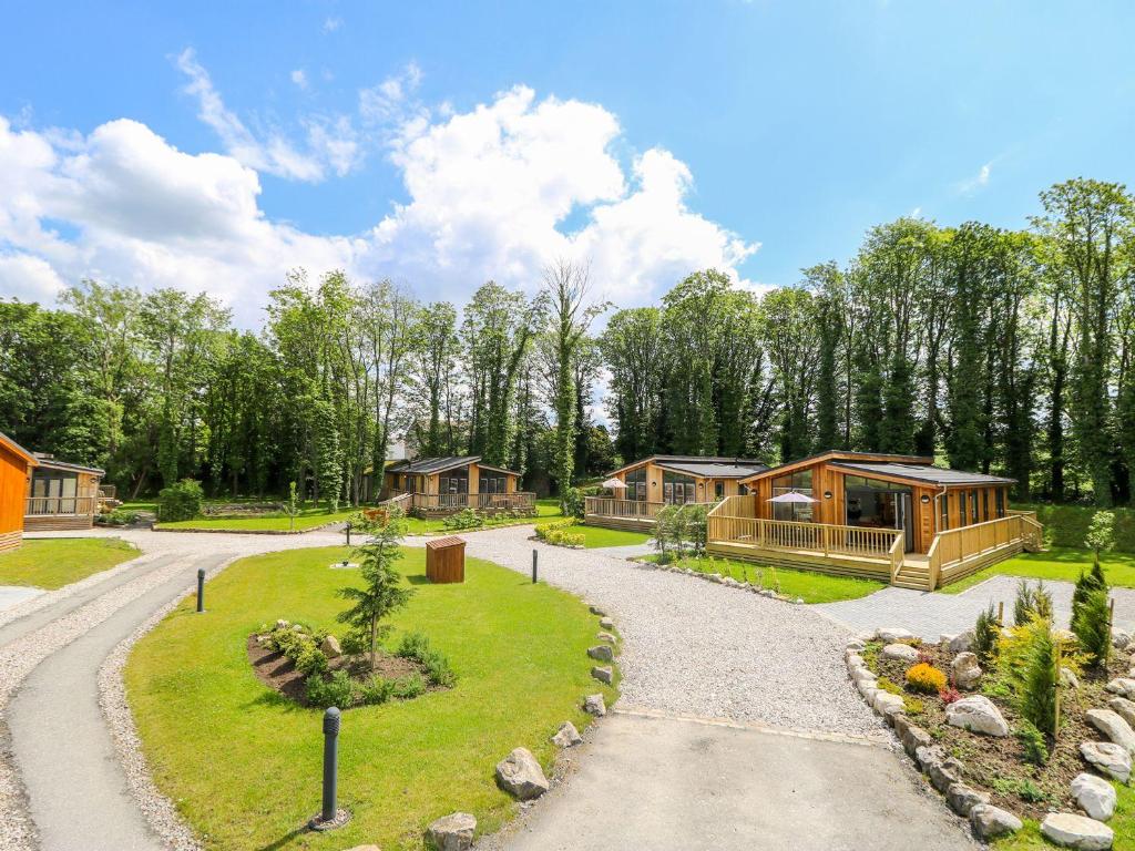 a group of lodges in the woods with a gravel road at Robin Lodge in Skipton