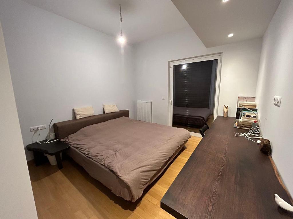 ein Schlafzimmer mit einem großen Bett und Holzboden in der Unterkunft ATHENS SEA VIEW GUEST HOUSE in Athen
